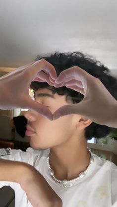 a woman making a heart shape with her hands