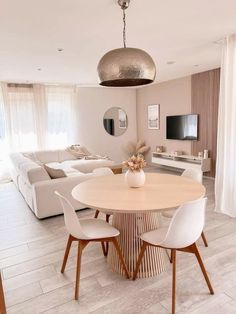 a living room and dining area with white furniture