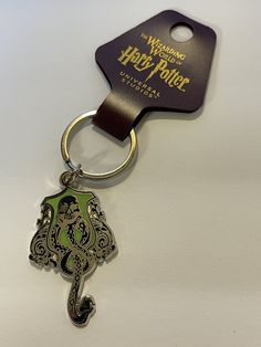 a harry potter keychain with a hogwarts crest on it