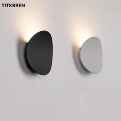 two black and white lights are on the wall