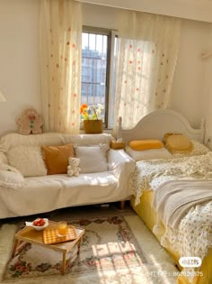 a living room with two beds and a couch in the corner next to a window