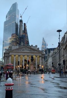 an empty street in the middle of a city with tall buildings on either side and people walking around