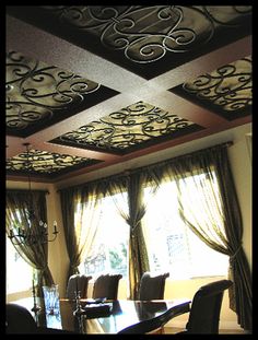 the dining room is decorated in black and white with intricate designs on the ceiling, along with drapes