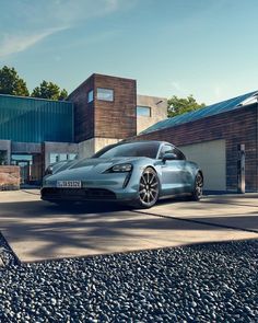 a blue sports car parked in front of a building