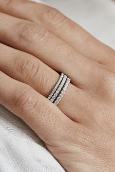 a woman's hand with three rings on her finger and the middle ring is white gold