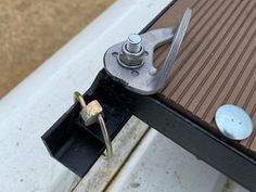 a close up of a piece of metal on top of a table with screws