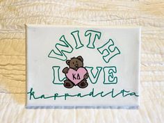 a patch with a teddy bear holding a heart in it's paws and the words, bite love hapquadiata