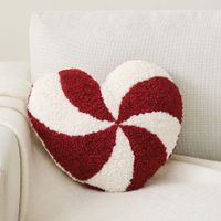 a red and white heart shaped pillow sitting on top of a couch