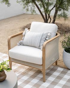 a chair sitting on top of a checkered rug next to a potted plant