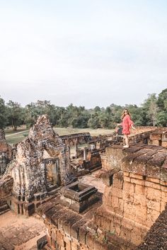 a woman standing on top of a stone structure