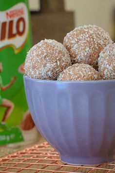 a blue bowl filled with powdered sugar covered donuts