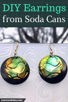 two earrings with green and yellow designs on them