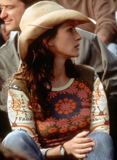 a woman wearing a cowboy hat sitting next to a man