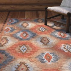 a wooden chair sitting on top of a floor next to a rug