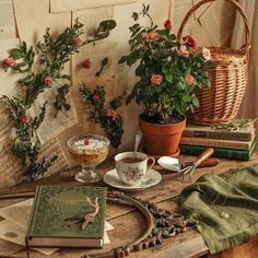 a table topped with books and plants next to a basket filled with flowers on top of it