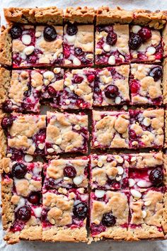 an image of berry bars on a sheet of parchment paper with blueberries and almonds