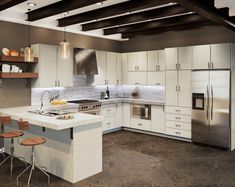 a kitchen with white cabinets and stainless steel appliances in it's center island, surrounded by bar stools