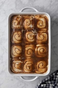 a pan filled with cinnamon rolls sitting on top of a counter