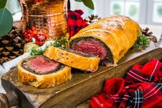 a meatloaf roll cut in half on a cutting board next to christmas decorations