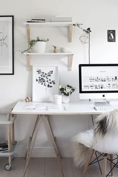 a white desk with two computer monitors on top of it and shelves above the desk