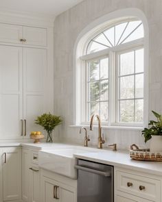 a kitchen with white cabinets and an arched window