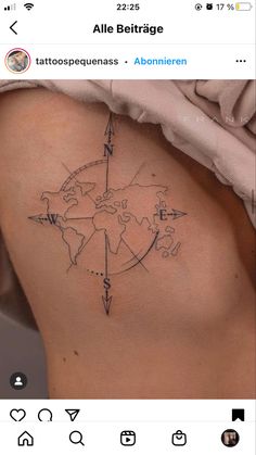 the back of a woman's stomach with an arrow and map tattoo on it