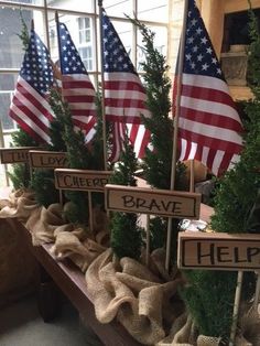 several wooden signs with american flags on them in front of a window and another sign that says help