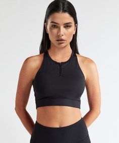 Experience the luxury of our soft performance sports bra with a high neck zipper front and opened back for a sexy silhouette. Our crop length bra has removable cups and is designed for high-to-low impact workouts. FEATURES: 4-way stretch technical fabric, breathable, and moisture wicking Trimmed front neckline Extra-wide straps for added support Wireless, molded, seam-free, removable cups Front lock zipper Front cell phone pocket consists of layered mesh paneling and proprietary shielding, which Set Active, Low Impact Workout, Black Sports Bra, Sport Bra, Mesh Panel, Wide Straps, Black Media, Front Zipper, Basic Tank Top