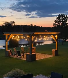 a gazebo with chairs and lights in the evening