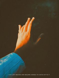 a person's hand reaching out towards the sky