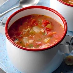 two white bowls filled with soup on top of a blue table