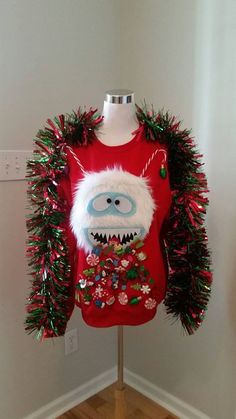 an ugly ugly sweater is on display in a room with white walls and wooden floors