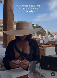 a woman in a hat sitting at a table