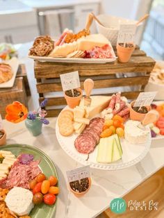 an assortment of cheeses, meats and breads on display at a buffet table