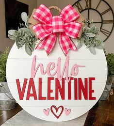 a sign that says hello valentine with a bow on it and succulents