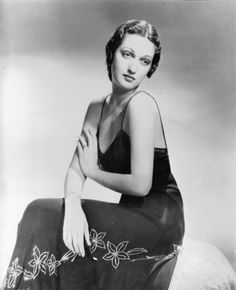 an old black and white photo of a woman in a dress sitting on a horse