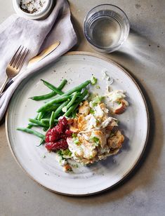 a white plate topped with green beans and potatoes