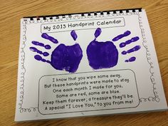 a purple handprint calendar on top of a wooden table