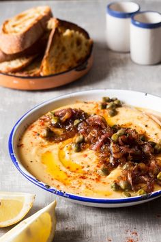 there is a bowl of soup with bread on the side