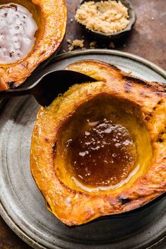 two baked delicacy dishes on a plate with spoons and sauce in them