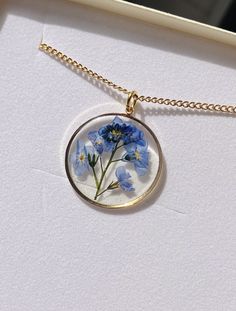 A beautiful and unique Botanical inspired terrarium necklace with real forget me not flowers. For memories of a close one, for true love and to show someone you will never forget them  💕 The flower is encapsulated in a crystal clear Resin which is Non-toxic, No VOCs, No fumes, No solvents, Non-flammable, Non-hazardous, No BPA.  The necklace chain is gold plated solid brass or stamped 14k gold filled chain as shown in last photo. This chain is much more long lasting and delicate. (this one is sh Gold Sterling Silver Necklaces With Pressed Flowers, Gold Sterling Silver Necklace With Pressed Flowers, Delicate Flower Birth Flower Jewelry, Dainty Birth Flower Jewelry For Keepsake, Yellow Gold Flower Pendant Necklace For Keepsake, Dainty Flower Necklace With Pressed Flowers, Blue Flower Jewelry With Natural Inclusions, Dainty Pressed Flower Necklace For Mother's Day, 14k Gold Filled Flower Pendant Jewelry Gift