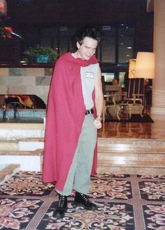 a woman in a red cape standing on the floor