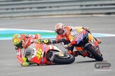 two motorcyclists are racing on the track in front of each other and one is leaning over