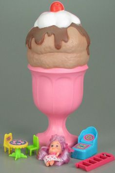 a toy ice cream sundae with toys around it