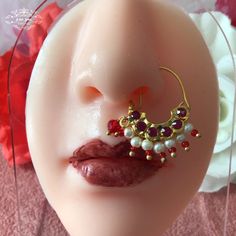 a close up of a fake head with jewelry on it's ear and nose