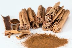 cinnamon sticks and spices on a white surface