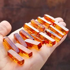 a person holding several pieces of glass in their hand, some are yellow and one is orange