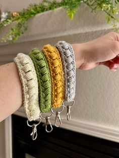 a woman's arm with four bracelets on it, one is yellow, the other is green