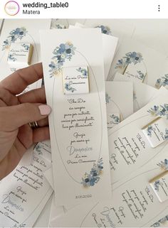 a person is holding some cards with flowers on them and the words are written in spanish