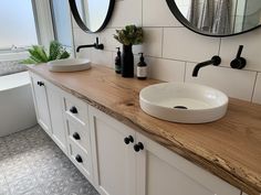 a bathroom with two sinks and mirrors on the wall